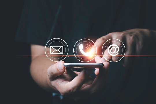 Hand touching to mobile phone with telephone email and address icon for customer service concept.