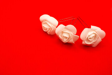 Fototapeta na wymiar three white rose ornaments in the head against a red background