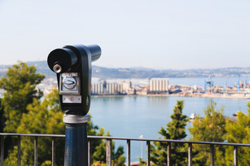 Sightseeing tourist coin operated telescope at watching point with scenic view at the port of...