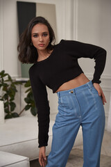 Fashion beautiful model sexy pretty lady dark tanned skin woman brunette hair wear denim jeans clothes casual office style or romantic date or party in decoration designer room home or hotel.