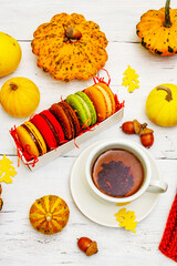 French macarons in autumn colors with cup of hot tea