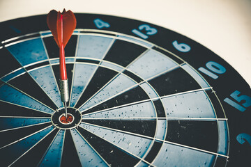 Close up shot of the dart arrow hit on bulleyes of dartboard to represent that the business reached...