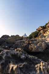 Fototapeta premium shot of a white Caucasian man walking on the rocks
