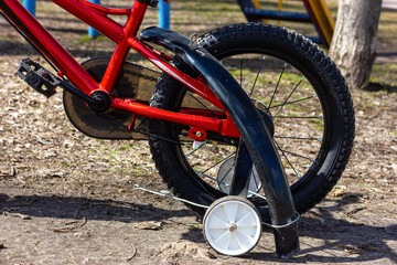 The bike needs repair. A torn fender on a kid's bike.