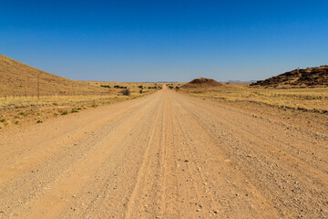 Straight gravel road through namib desert in Namibia