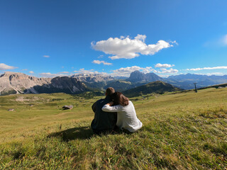 Fototapeta na wymiar Giovane coppia seduta, magnifico panorama dal monte Seceda