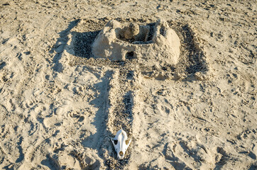 Golden Sand Castle with Trench and an Animal Skull Placed to Complete the Medieval Theme Decoration. Located in a Greek Beach in Crete Island, Greece During Summer Season.