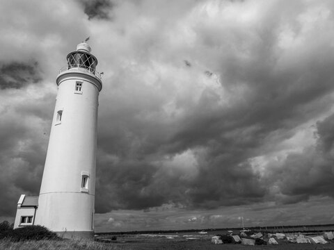 black and white photo of Hurst Point Lighthouse on a stormy day