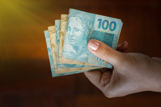 Hands holding Brazilian real notes - Money from Brazil - Notes of Real - Brazil BRL banknote