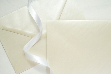 Blank envelope mockup, champagne color wedding envelope and white ribbon for return address label,...