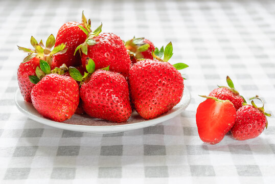 Ripe Strawberries In A White Plate On The Table