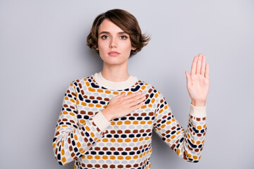 Portrait of pretty calm peaceful brown-haired girl saying oath isolated over grey pastel color...