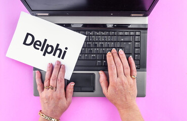Delphi programming language. Word Delphi on paper and laptop