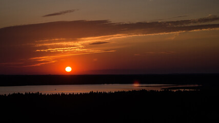 Colorful sunset on lake Usma in Latvia. Above the tops of the trees.