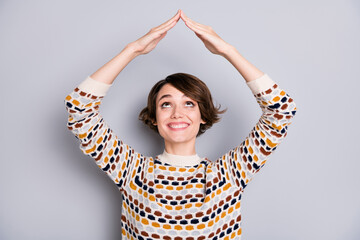 Portrait of lovely funny girl holding making like roof over head having fun isolated over grey pastel color background