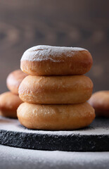 Fototapeta na wymiar Sweet donuts with powder sugar on black background. Food concept.