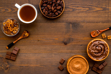 Cocoa beans and powder with hot chocolate in white cup. Top view, flat lay