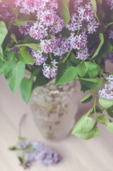 A bouquet of purple lilac in a glass vase.