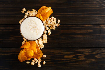lager beer and snacks on wooden table. Nuts, chips, crackers. Craft beer. Beerboard.
