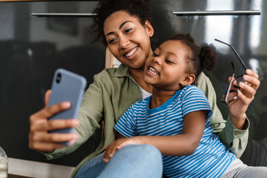 Black Smiling Mother And Daughter Taking Selfie On Mobile Phone