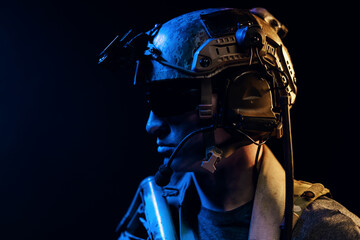 Portrait of special forces soldier in helmet and glasses in the dark