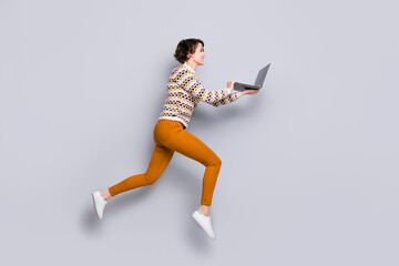 Fototapeta na wymiar Full length body size profile side view of lovely cheery girl jumping running using laptop isolated over grey pastel color background