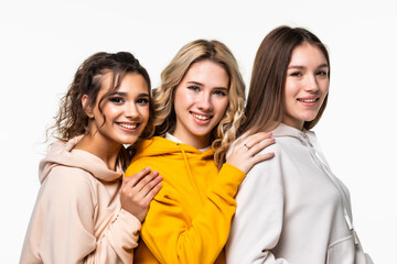 Fototapeta premium Three young women in casual clothing standing isolated on white background