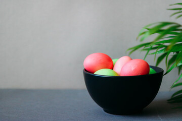 Colorful Easter eggs in black bowl with empty space for text