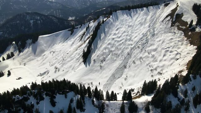 Snow avalanche in the alps on Sch&ouml;nberg in Bavaria, Germany, Aerial shot in 4k in winter 2021, drone