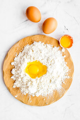 Making dough concept. Pile of flour and eggs on white background top view