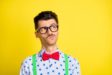 Photo of young handsome man think thoughtful guess wonder minded look empty space isolated over yellow color background