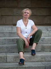 Old and stylish woman on a summer walk in beautiful city.