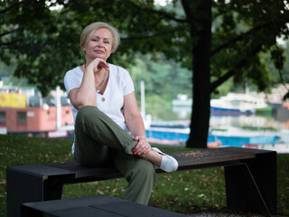 Old and stylish woman on a summer walk in beautiful city.