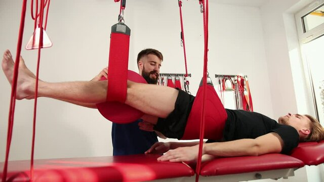 Orthopedic doctor makes a diagnosis of the muscle tone on legs. Manual therapy