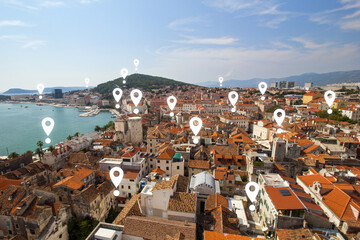 Map pin icons on Split's cityscape. View of Split's historic Diocletian's Palace, old town and Marjan hill from above in Croatia.