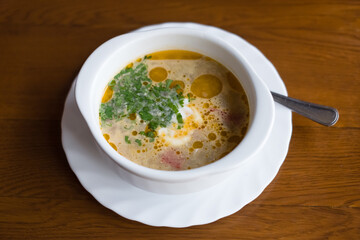 A plate with a red borscht on the table close-up