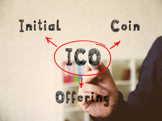  ICO Initial Coin Offering on Concept photo. Hand holding marker for writing isolated on background.