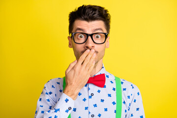 Photo of young man nervous panic worried oops mistake fail cover lips hand isolated over yellow color background