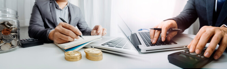 Businesswomen hands working with finances about cost and calculator and laptop with tablet, smartphone at office in morning light