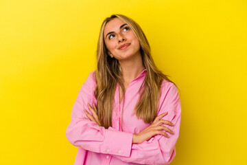 Young blonde caucasian woman isolated on yellow background dreaming of achieving goals and purposes