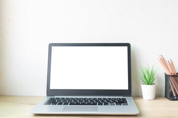 Fototapeta premium Laptop computer with white blank screen on desk in workspace and copy space concept