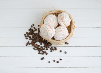 Coffee marshmallow on a white wooden background with yellow bokke and coffee beans. Light dessert for the holiday