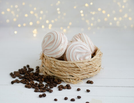 Coffee marshmallow on a white wooden background with yellow bokke and coffee beans. Light dessert for the holiday