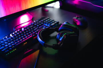 gamer work space concept, top view a gaming gear, mouse, keyboard, joystick, headset with rgb color on black table background. © ekkaphan