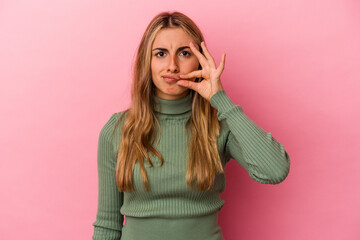 Young blonde caucasian woman isolated on pink background with fingers on lips keeping a secret.