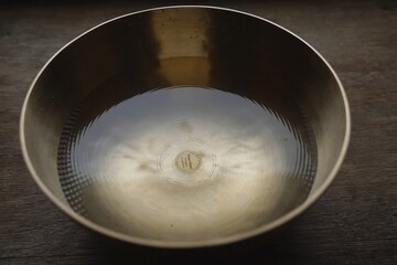 Singinn bowl filled with water for sound healing therapy 
