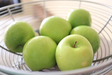 Green apples in the basket.