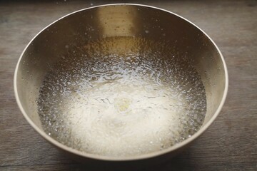 Water drops close up in tibetan singing bowl for sound healing therapy.