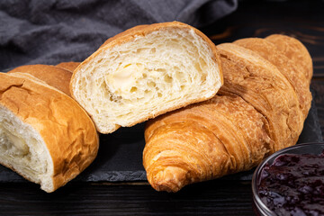 fresh croissants with jam on dark background