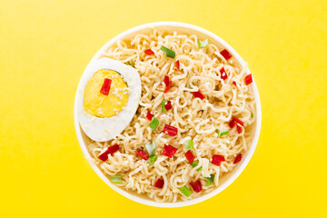  noodles with vegetables and egg in bowl on yellow background top view with copy spaces
